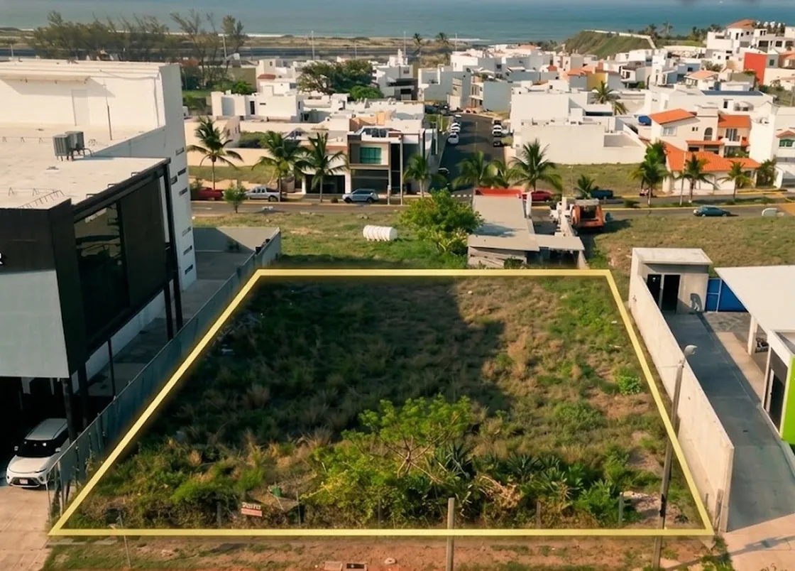 Vista aérea del terreno con su perímetro marcado en amarillo, rodeado de construcciones comerciales y residenciales